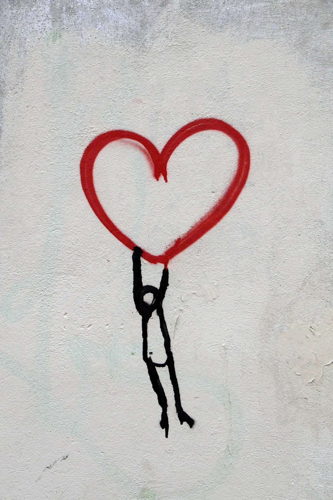 graffiti of stickman hanging from a heart